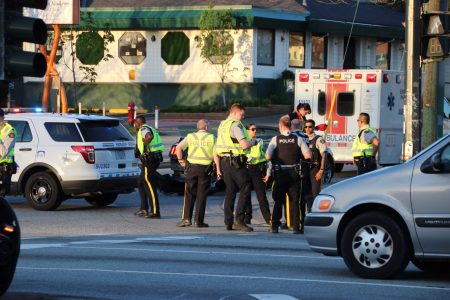 Multiple police officers congregated following a crash between a marked RCMP SUV and a Mustang convertible at 104 Ave & King George Blvd. Taken 4/25/2018 by <a href="https://vancouverfirepics.smugmug.com/RCMP-mvi/n-nHSP5q/i-dZrW3fN">Shane MacKichan</a>