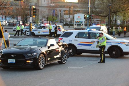A police cruiser and Mustang convertible at the intersection of 104 Ave & King George Blvd following a collision. Taken 4/25/2018 by <a href="https://vancouverfirepics.smugmug.com/RCMP-mvi/n-nHSP5q/i-dZrW3fN">Shane MacKichan</a>