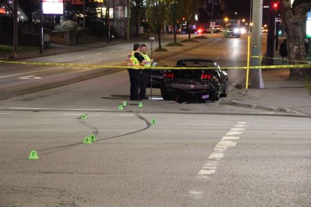 A damaged Mustang convertible at the intersection of 104 Ave & King George Blvd following a collision. The intersection is closed and investigation markers have been placed over the skid marks that traverse through the middle of the intersection. Taken 4/25/2018 by <a href="https://vancouverfirepics.smugmug.com/RCMP-mvi/n-nHSP5q/i-dZrW3fN">Shane MacKichan</a>